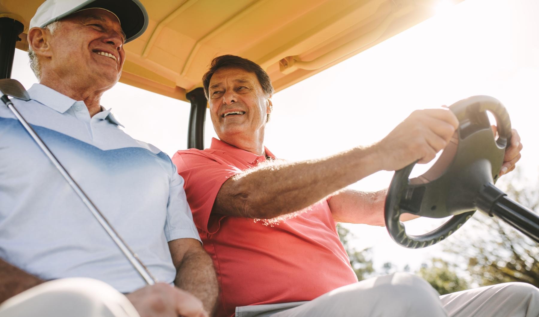 two people in a golf cart together smiling