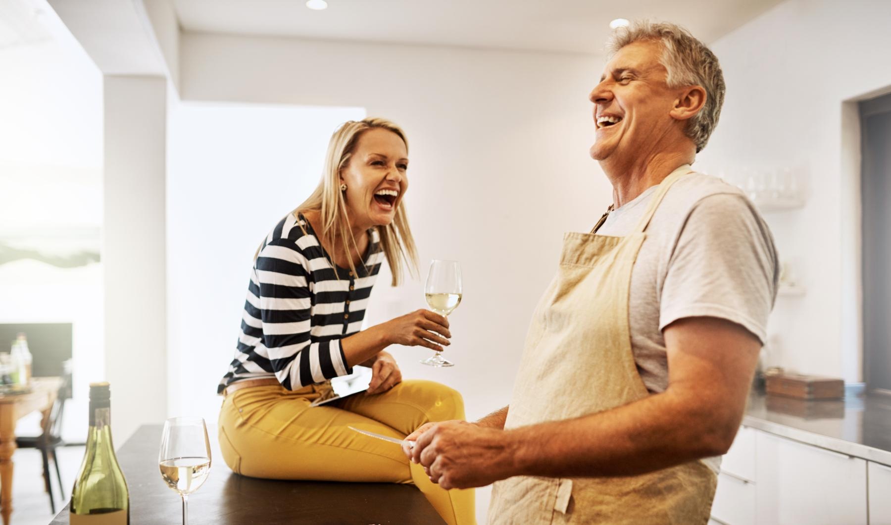 a man and a woman laughing in a kitchen